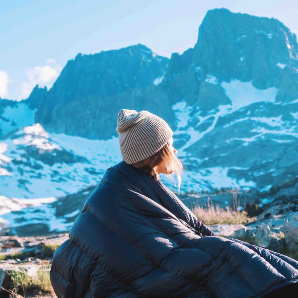 Hyperlite Mountain Gear 40-Degree Quilt wrapped around a hiker with a mountain view